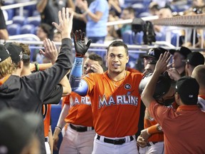 Miami Marlins' Giancarlo Stanton, center, is congratulated by teammates after he hit a home run during the third inning of a baseball game against the Colorado Rockies, Sunday, Aug. 13, 2017, in Miami. (AP Photo/Wilfredo Lee)