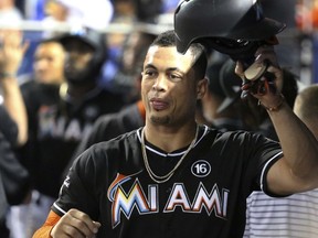 Miami Marlins' Giancarlo Stanton celebrates with teammates after he scored during the first inning of a baseball game against the Colorado Rockies, Saturday, Aug. 12, 2017, in Miami. (AP Photo/Wilfredo Lee)