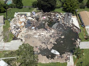 This August 4 photo shows a large sinkhole in the Lake Padgett Estates community in Land O' Lakes, Fla. Florida officials say more homes could possibly be condemned due to a massive sinkhole that has already made seven homes unlivable, including two that were consumed entirely by the collapsing hole.