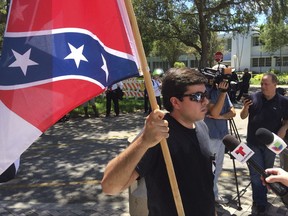 Chris Tedino, a member of the League of the South, protests Wednesday, Aug. 30, 2017, outside Hollywood, Fla., City Hall, against a proposal to strip the names of Confederate Gens Robert E. Lee, Nathan Bedford Forrest and John Bell Hood from city streets. Tedino was later arrested after assaulting another protestor. (AP Photo/Terry Spencer)