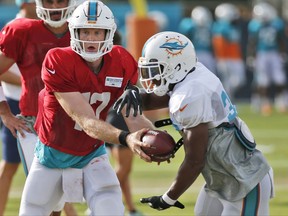 Miami Dolphins quarterback Ryan Tannehill, left, hands off to running back Kenyan Drake an NFL football training camp, Thursday, Aug. 3, 2017, at the Dolphins training facility in Davie, Fla. (AP Photo/Wilfredo Lee)