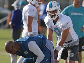 Miami Dolphins quarterback Matt Moore (8) takes a snap as he runs through drills during an NFL football training camp, Friday, Aug. 4, 2017, at the Dolphins training facility in Davie, Fla. (AP Photo/Wilfredo Lee)