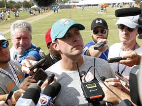 Miami Dolphins head coach Adam Gase, center, talks with members of the media after an NFL football training camp, Friday, Aug. 4, 2017, at the Dolphins training facility in Davie, Fla. (AP Photo/Wilfredo Lee)