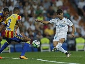 Real Madrid's Marco Asensio, right, scores the opening goal past Valencia's Ruben Vezo during a Spanish La Liga soccer match between Real Madrid and Valencia at the Santiago Bernabeu stadium in Madrid, Sunday, Aug. 27, 2017. (AP Photo/Francisco Seco)