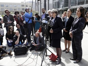 File - In this July 10, 2017 file photo, Oakland city officials including Mayor Libby Schaaf, right, city administrator Sabrina Landreth, second from right, and police chief Anne Kirkpatrick, at podium, field questions after a federal court hearing about police sexual misconduct in San Francisco. The teenage daughter of a police dispatcher at the center of a Northern California sexual misconduct scandal involving two dozen officers has filed suit against one of the law enforcement agencies, her attorney announced Friday, Aug. 18, 2017. The 19-year-old filed the federal lawsuit in San Francisco Thursday, Aug. 17, 2017. (AP Photo/Marcio Jose Sanchez, File)