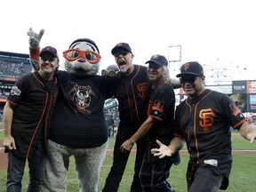 Metallica members, from, left, Lars Ulrich, San Francisco Giants mascot Lou Seal, James Hetfield, Kirk Hammett and Robert Trujillo pose for photos before a baseball game between the San Francisco Giants and the Chicago Cubs Monday, Aug. 7, 2017, in San Francisco. (AP Photo/Marcio Jose Sanchez)