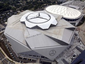 The new Mercedes-Benz Stadium, foreground, stands next to the Georgia Dome in aerial photo before an NFL preseason football game between the Atlanta Falcons and the Arizona Cardinals, Saturday, Aug. 26, 2017, in Atlanta. (Akili-Casundria Ramsess/Atlanta Journal & Constitution via AP)