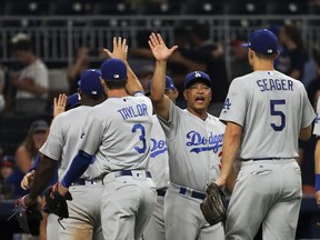 Los Angeles Dodgers manager Dave Roberts (30),center, celebrates with his players after defeating the Atlanta Braves in a baseball game Tuesday, Aug. 1, 2017, in Atlanta. The Dodgers won 3-2. (AP Photo/John Bazemore)