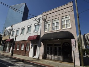 This Wednesday, July 19, 2017, photo shows a two-story brick building, right, at the northwest edge of Atlanta's old downtown. The old building is where the first country music hit was recorded in 1923 by Fiddlin' John Carson. It faces the threat of demolition to make way for a Jimmy Buffett's Margaritaville restaurant. (AP Photo/Mike Stewart)