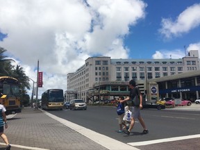 Tourists walk in Tumon, Guam Monday, Aug. 14, 2017. Tourists haven't been deterred from visiting the tropical island of Guam even though the U.S. territory has been the target of threats from North Korea during a week of angry words exchanged by Pyongyang and Washington. (AP Photo/Tassanee Vejpongsa)