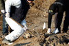 Forensic experts exhume a mass grave in the village of Kozluk, Bosnia, in 2015.