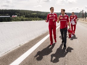 Ferrari driver Sebastian Vettel of Germany, center, walks in the pit lane ahead of the Belgian Formula One Grand Prix in Spa-Francorchamps, Belgium, Thursday, Aug. 24, 2017. (AP Photo/Geert Vanden Wijngaert)