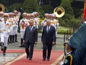 Turkish Prime Minister Binali Yildirim, center right, and his Vietnamese counterpart Nguyen Xuan Phuc, center left, review an honor guard in Hanoi, Vietnam Wednesday, Aug. 23, 2017. Yildirim is on a two-day visit to the Southeast Asian country to boost trade and defense ties between the two countries. (AP Photo/Tran Van Minh)