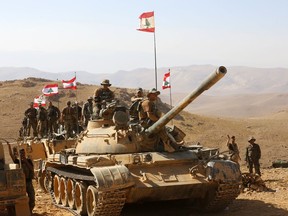 Lebanese soldiers rest on top of an armored personnel carrier during a media trip organized by the Lebanese army, on the outskirts of Ras Baalbek, northeast Lebanon, Monday, Aug. 28, 2017. Lebanon's Hezbollah TV is reporting that Islamic State militants started leaving the border area with Syria on Monday as part of a negotiated deal to end the extremist group's presence there. (AP Photo/Hassan Ammar)