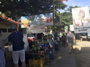 People walk through the Chamorro Village marketplace in Hagatna, Guam, Wednesday, Aug. 9, 2017. The market is popular among U.S. military members, locals and tourists in the territory's capital city. Residents of the tiny Pacific island say they're afraid of being caught in the middle of escalating tensions between the U.S. and North Korea after Pyongyang announced it was examining plans for attacking the strategically important U.S. territory. (AP Photo/Grace Garces Bordallo)