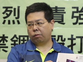 Democracy party member Howard Lam displays a photo of soccer star Lionel Messi during a press conference in Hong Kong, Friday, Aug. 11, 2017. Hong Kong's main pro-democracy party says Lam was briefly abducted and tortured by suspected mainland Chinese security agents because he planned to send a signed photo of soccer star Lionel Messi to a dissident's widow. (AP Photo/Apple Daily)