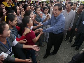 Cambodia's Prime Minister Hun Sen greets garment workers during a visit to the Phnom Penh Special Economic Zone on  the outskirts of Phnom Penh, Cambodia, Wednesday, Aug. 23, 2017. Two Cambodian radio stations, known for their rare stances independent of government control, said Wednesday they were being forced to shut down their operations, shrinking the space left for political activity and free expression ahead of next year's general election. (AP Photo/Heng Sinith)