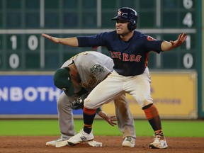 Houston Astros' Jose Altuve gestures as he safely steals second base ahead of the throw to Oakland Athletics shortstop Marcus Semien in the eighth inning of a baseball game, Sunday, Aug. 20, 2017, in Houston. (AP Photo/Richard Carson)