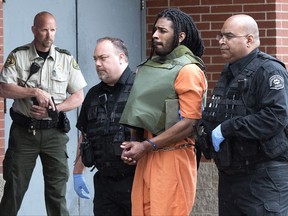 FILE - In this May 10, 2017, file photo, Wesley Correa-Carmenaty is led into the Woodbury County Jail in Sioux City, Iowa. Correa-Carmenaty, who is charged with killing a sheriff's deputy and wounding another while escaping from an Iowa jail, entered guilty pleas Tuesday, Aug. 15, 2017, to murder, attempted murder, escape, kidnapping and other crimes. His trial was set to begin Tuesday, but his attorney informed authorities last week that Correa-Carmenaty would change his plea in Pottawattamie County District Court in Council Bluffs. (Tim Hynds/Sioux City Journal via AP)