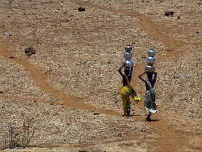 FILE- In this May 4, 2016 file photo, Indian women walk home after collecting drinking water from a well at Mengal Pada in Thane district in Maharashtra state, India. A new study suggests wide swaths of northern India, southern Pakistan and parts of Bangladesh may become so hot and humid by the end of the century it will be deadly just being outdoors. Such conditions would threaten up to a third of the 1.5 billion people living in those regions, unless the global community can rein in climate-warming carbon emissions. (AP Photo/Rajanish Kakade, File )