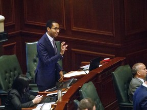 In this May, 31, 2017 file photo, Rep. Christian Mitchell, D-Chicago, speaks on the House floor at the Capitol in Springfield, Ill. A political cartoon circulated by a conservative Illinois think tank with ties to Republican Gov. Bruce Rauner has triggered accusations of racism and insensitivity. The rendering depicted a black school child from Chicago begging for money from a cigar-smoking white man in a suit. "There is a way to make a policy point that's legitimate, but not in a way that caricatures African Americans and provokes a dark history," said Mitchell.(Rich Saal/The State Journal-Register via AP)