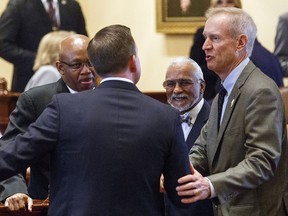 FILE - In this Aug. 29, 2017 file photo, Gov. Bruce Rauner, right, speaks with Sen. Andy  Manar, D-Bunker Hill, on the Senate floor after the chamber approved a landmark education funding reform at the Capitol in Springfield, Ill. Rauner is set to sign the legislation Thursday, Aug. 31, 2017, that will change the way the state funds schools, a plan he said will ensure every child "gets a chance at an excellent education regardless of their parents' income" or where they live. (Rich Saal/The State Journal-Register via AP File)/The State Journal-Register via AP)