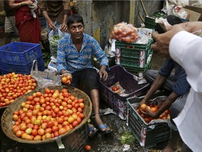 A vendor sells tomatoes at a market place in Mumbai, India.