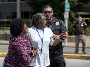 The sister of the man who was shot and killed by law enforcement in front of the Winfield K. Denton Federal Building, center, is seen shortly after the shooting Tuesday, Aug. 29, 2017. The man has been identified as Ricky Ard, 55, of Evansville. A witness told police Ard was swinging a bat as he approached a police officer. (Marlena Sloss /Evansville Courier & Press via AP)