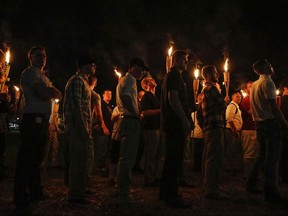 In this Friday, Aug. 11, 2017 photo, multiple white nationalist groups march with torches through the UVA campus in Charlottesville, Va. W.C. Bradley Co. President and CEO Marc Olivie told the Columbus Ledger-Enquirer on Monday, Aug. 14 that the Columbus-based company's staff was "appalled and saddened" that its Tiki brand torches were "used by people who promote bigotry and hatred." (Mykal McEldowney/The Indianapolis Star via AP)