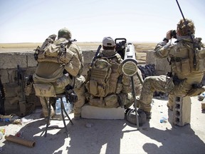 Belgian special forces soldiers sit on a rooftop with a guided-missile launcher, a few miles from the frontline, in the village of Abu Ghaddur, east of Tal Afar, Iraq, Sunday, Aug. 20, 2017. U.S.-backed Iraqi forces have launched a multi-pronged assault to retake the town of Tal Afar, west of Mosul, marking the next phase in the country's war on the Islamic State group. Tal Afar and the surrounding area is one of the last pockets of IS-held territory in Iraq after victory was declared in July in Mosul, the country's second-largest city. (AP Photo/Balint Szlanko)