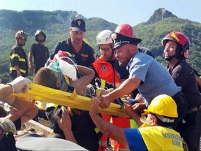 Firefighters and rescuers pull out a boy, Mattias, from the collapsed building in Casamicciola, on the island of Ischia, near Naples, Italy, a day after a 4.0-magnitude quake hit the Italian resort island, Tuesday, Aug. 22, 2017. irefighters freed a 7-month-old baby and an older brother from rubble of a house some seven hours after the quake, and are continuing work on rescuing another brother who remained trapped. (Italian Carabinieri, HO/ANSA via AP)