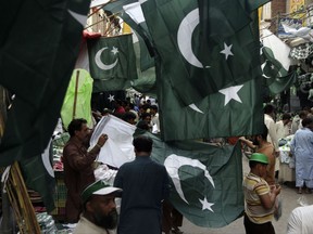 People buy flags to celebrate Pakistan's independence day, in Lahore, Pakistan, Sunday, Aug. 13, 2017. The nation will celebrate their 70th Independence Day on Monday, having gained its independence from British colonial rule in 1947. (AP Photo/K.M. Chaudary)