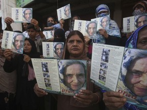 People hold pictures of Ruth Pfau, a German doctor and nun who devoted her life to the eradication of leprosy in Pakistan, in Karachi, Pakistan, Friday, Aug. 18, 2017. Pakistan's prime minister has announced a state funeral for Ruth Pfau. The funeral will take place on Saturday. (AP Photo/Fareed Khan)