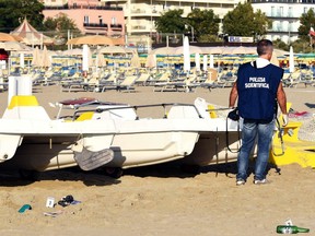 A forensic police officer inspects the area where a suspected gang rape of a Polish tourist and the beating of her partner took place, in Rimini, Italy, Saturday, Aug. 26, 2017.