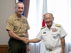 Chairman of the Joint Chiefs of Staff Joseph Dunford, left, poses with Japanese Chief of Staff, Joint Staff Adm. Katsutoshi Kawano for a photo during a meeting at Defense Ministry in Tokyo, Friday, Aug. 18, 2017. (AP Photo/Andrew Harnik)