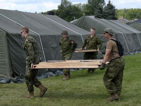 Canadian Forces members work on the interim lodging site outside Cornwall's Nav Centre, which is temporarily housing U.S. asylum seekers, on Wednesday, Aug. 23, 2017. THE CANADIAN PRESS/Justin Tang