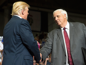 U.S. President Donald Trump shakes hands with West Virginia Governor Jim Justice, who announced during a rally on Thursday that he would switch parties from Democrat to Republican.