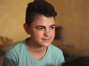 In this Monday, July 31, 2017 photo, Syrian refugee Ali al-Sbehi, 15, gives an interview to The Associated Press at his home in Manshiyeh, northern Jordan. Since his family fled civil war in Syria five years ago, Ali hasn't set foot in a school and has instead put in 12-hour shifts in a supermarket, a fast food stand and now a coffee shop, enduring abuse from employers, back-breaking work and low pay because he is the sole breadwinner for his family of eight. Ali is among more than half a million Syrian refugee children in regional host countries - Jordan, Lebanon, Turkey, Egypt and Iraq - who aren't in school, despite an ambitious "no lost generation" pledge made by donor countries at a Syria aid conference in February 2016. (AP Photo/Reem Saad)
