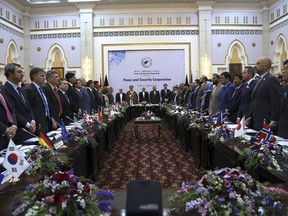 FILE - In this June 6, 2017 photo, Afghan President Ashraf Ghani, center, and delegates stand for the national anthem during the Kabul Process conference, at the Presidential Palace in Kabul, Afghanistan. Despite seemingly stalemated peace talks between Afghanistan's government and the Taliban, officials familiar with the efforts say the country's intelligence chief has exchanges by telephone nearly every day with leaders of the militant group. (AP Photo/Rahmat Gul, File)