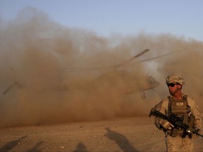 FILE - In this Aug. 27, 2017 file photo, a U.S. Marine takes part during a training session for Afghan army commandos in Shorab military camp in Helmand province, Afghanistan. Despite seemingly stalemated peace talks between Afghanistan's government and the Taliban, officials familiar with the efforts say the country's intelligence chief has exchanges by telephone nearly every day with leaders of the militant group. (AP Photo/Massoud Hossaini, File)