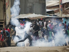 Supporters of Kenyan opposition leader and presidential candidate Raila Odinga throw back a tear gas canister at Kenyan security forces in the Mathare slum of Nairobi Wednesday , Aug. 9, 2017