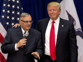 FILE - In this Jan. 26, 2016, photo, Republican presidential candidate Donald Trump is joined by Maricopa County, Ariz., Sheriff Joe Arpaio at a campaign event in Marshalltown, Iowa. President Trump says he may grant a pardon to former Sheriff Joe Arpaio following his recent conviction in federal court, prompting outrage among critics who say the move would amount to an endorsement of racism. (AP Photo/Mary Altaffer, File)