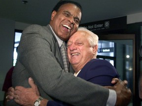 FILE - In this Sept. 28, 2000, file photo, Tommy Hawkins, left, Los Angeles Dodgers vice president of external affairs, left, greets Tommy Lasorda, former Dodgers manager and manager of the American gold medal Olympics baseball team, on the team's arrival at Los Angeles International Airport from Australia. Hawkins, the first black athlete to earn All-America honors in basketball at Notre Dame and who played for the Los Angeles Lakers during a 10-year NBA career, has died. He was 80. (AP Photo/Kim D. Johnson, File)