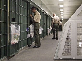 FILE - In this Oct. 3, 2012, file photo, Los Angeles County Sheriff's deputies inspect a cell block at the Men's Central Jail in downtown Los Angeles. The largest sheriff's department in the U.S. uses unsound methods to compile data about violence in Los Angeles County jails and provided inaccurate statistics about jailhouse assaults to news organizations and its oversight agency, according to a report released Wednesday Aug. 9, 2017. (AP Photo/Reed Saxon, File)