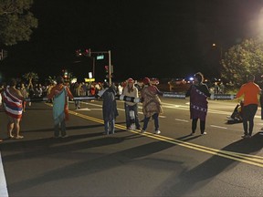 This Wednesday, Aug. 2, 2017, photo provided by the Hawaii Department of Land and Natural Resources (DLNR) shows protestors blocking the intersection of Kula Highway and Old Haleakala Highway in Maui, Hawaii. Protestors connected themselves with PVC piping to form a human chain across the road to try to block an equipment convoy for the Daniel K. Inouye Solar Telescope being built at the summit of Haleakala, a Hawaii mountain held sacred by Native Hawaiians. Several people were arrested. (Hawaii DLNR via AP)