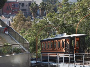 This Wednesday, Aug. 30, 2017 photo shows a resident doing early morning exercise next to Angels Flight railroad in downtown Los Angeles. The little funicular that carried Emma Stone and Ryan Gosling to the top of downtown Los Angeles in the movie "La La Land" is scheduled to reopen to the general public Thursday. (AP Photo/Richard Vogel)