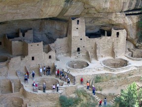 FILE - In this Aug. 27, 2005 file photo, visitors tour Cliff Palace,an ancient cliff dwelling in Mesa Verde National Park, Colo. Researchers say they have new evidence that ancestral Pueblo people who disappeared from the Mesa Verde cliff dwellings of southwestern Colorado 700 years ago migrated to what is now New Mexico. DNA from the bones of domesticated turkeys. The turkey DNA shows Native American people in the Rio Grande Valley of northern New Mexico raised and ate the same genetic strain of bird as the Mesa Verde people, and that the turkeys arrived in New Mexico about the same time Mesa Verde was abandoned, the researchers said. (AP Photo/Beth J. Harpaz,File)