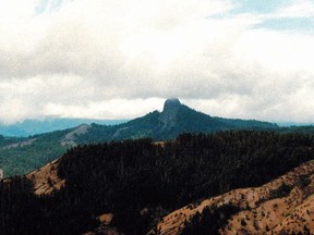 FILE- In this July 6, 2000, file photo, Pilot Rock rises into the clouds in the Cascade-Siskiyou National Monument near Lincoln, Oregon. Oregon and its political leaders await word on whether the Trump administration will shrink the Cascade-Siskiyou National Monument, a 112,000-acre monument along the border with California, Friday, Aug. 25, 2017. (AP Photo/Jeff Barnard, File)