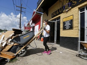 Pre-med student Sheila Tendero, from the Miami Medical Team, helps gut the Zulu Social Aid & Pleasure Club Store, which flooded during rain storms this past weekend, in New Orleans, Wednesday, Aug. 9, 2017. (AP Photo/Gerald Herbert)