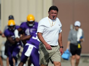 In this Aug. 23, 2017 photo, LSU football head coach Ed Oregon walks across the field during an NCAA college football practice in Baton Rouge, La. Orgeron grew up an LSU fan in Cajun country along the Bayou Lafourche in Larose, Louisiana, where his mother still lives. The Tigers' coach is about to begin his first full season on the job after taking over for Les Miles during last season. His Louisiana and Cajun roots made him a popular choice to keep the job long term.(AP Photo/Gerald Herbert)